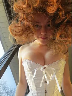 gingerpuss in a corset playing with the camera