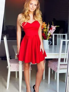 hot blonde doll posing in sexy low cut red dress with exposed shoulders and some black high heeled open toe platforms