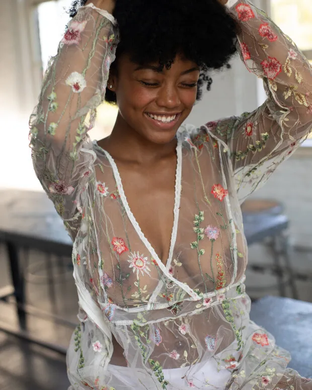 cute black woman smiling showing her tits in see through lingerie