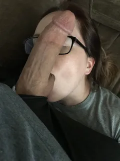 amateur brunette with glasses has a huge cock placed on her face while sucking balls