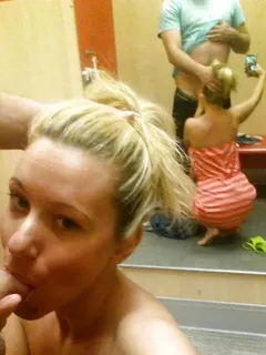 amateur blond in the dressing room giving a mirror-shot while she blows