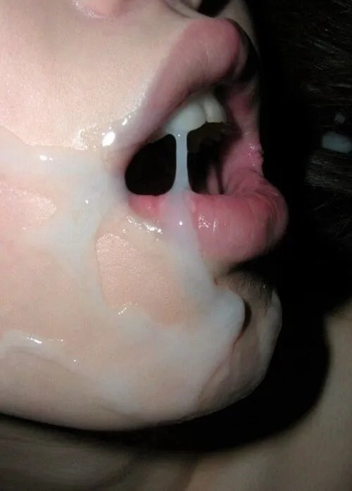 mouth gaping wide open, she's trying to get cum in her mouth to taste and swallow.  a huge wad of cum, dripping down her face and teeth.