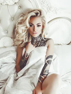 white bed with tattooed blonde.