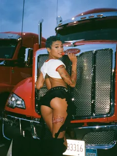 coi leray posing in front a truck with a lollipop.