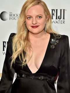 elisabeth moss braless boobs showing nice cleavage in a low cut black dress photographed by paparazzi.