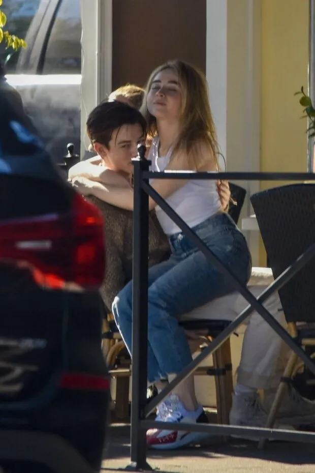 sabrina carpenter braless boobs in a white tank top showing off her tits also sitting in her boyfriends lap kissing seen by paparazzi.