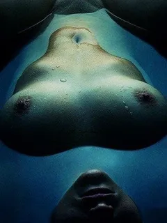 interesting nude photograph aquatic blue floating on back with boobs and face above surface pussy submerged with  moon lighting effect.