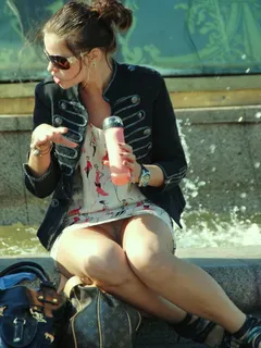 woman sitting by fountain gives an upskirt view